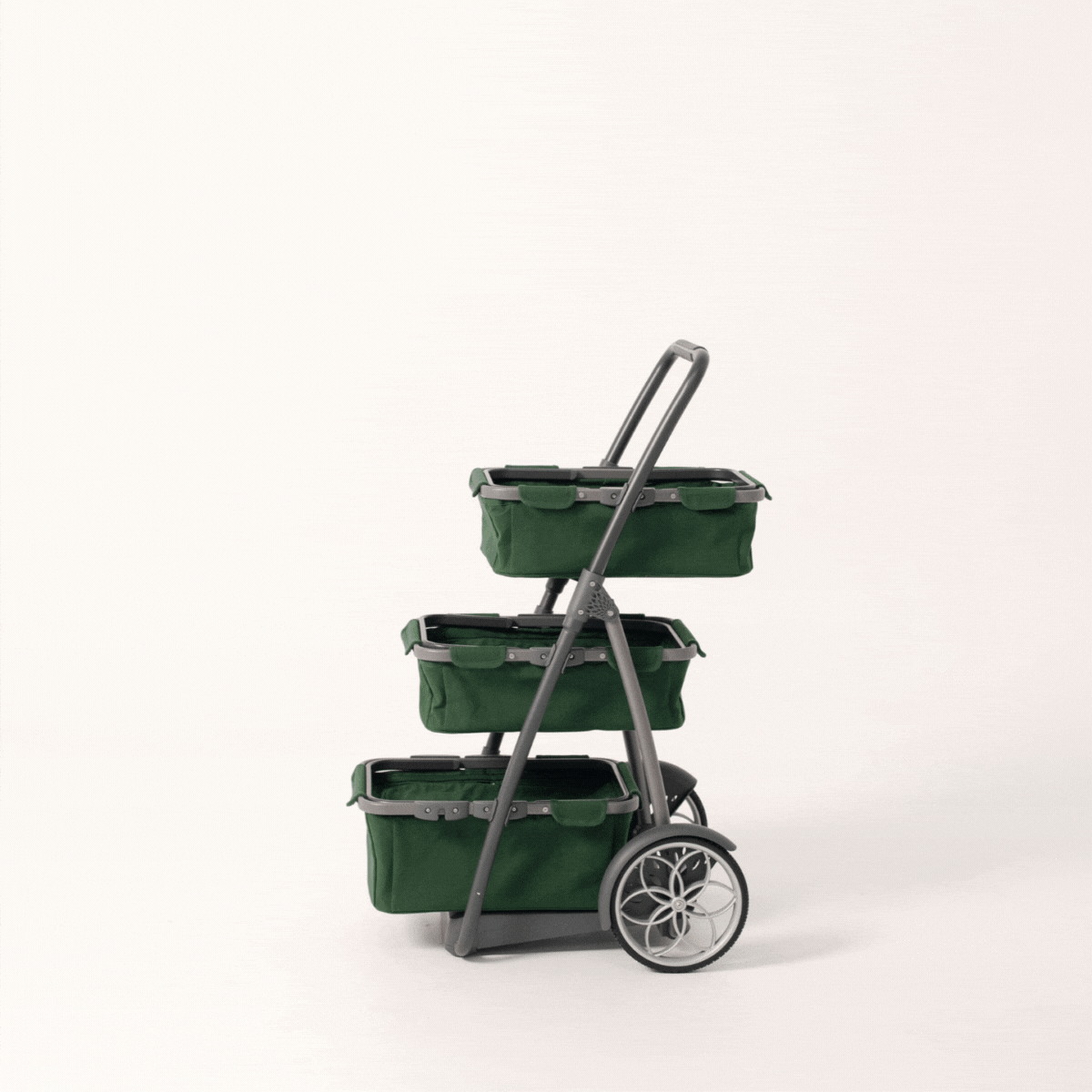 Green shopping trolley / marketday cart with flower design wheel and canvas baskets spinning around on one spot